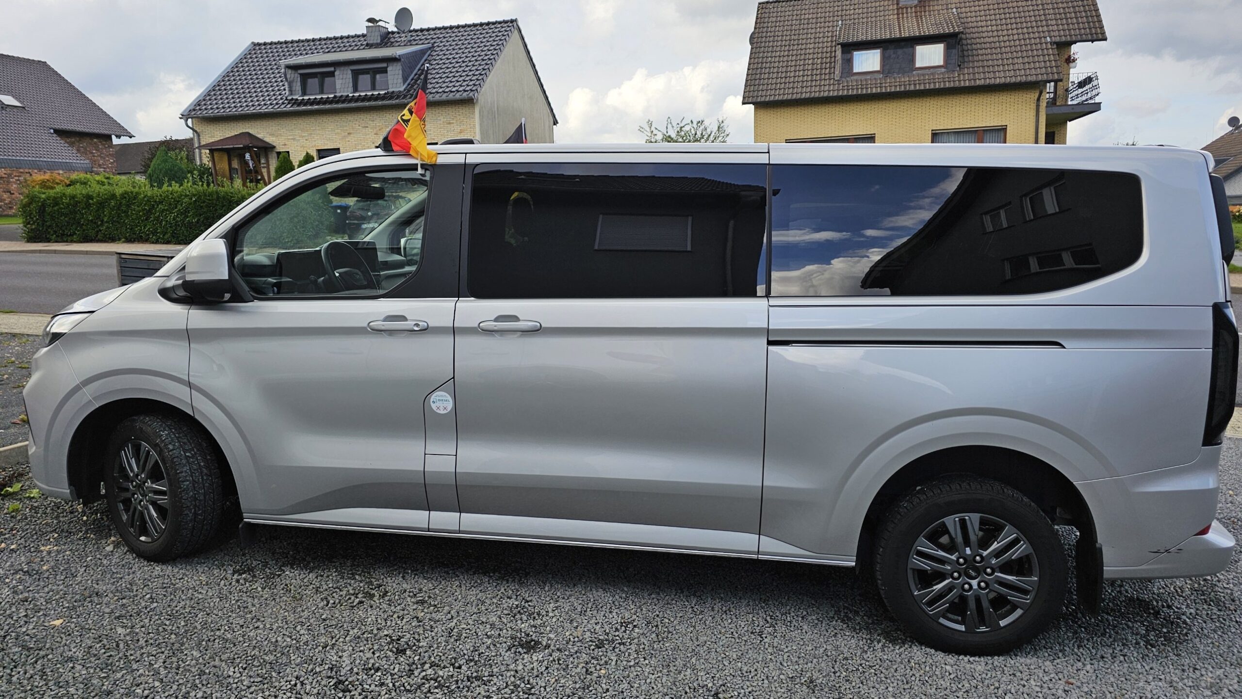 Der Van von der Seite, mit einer deutschen Fahne auf dem Dach